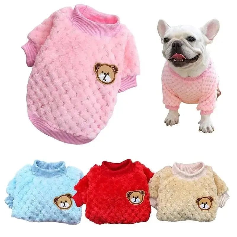 A collection of dog vests in pink, blue, red, and beige, displayed on a white background, with a dog wearing the pink vest.