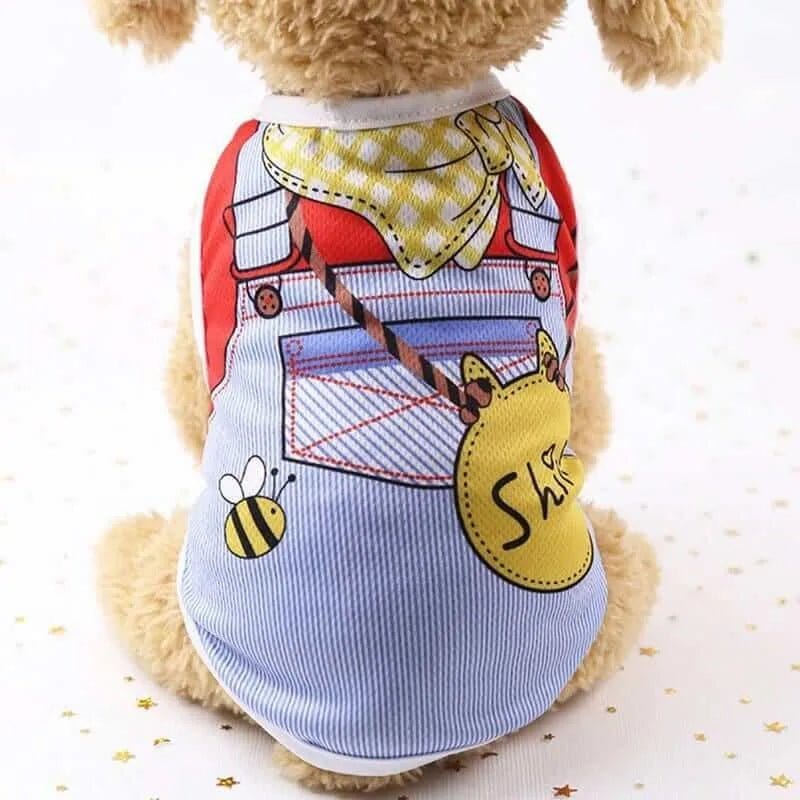 Small dog wearing a mesh vest with a printed overall design, yellow bandana, and a round yellow tag with the text Shi.