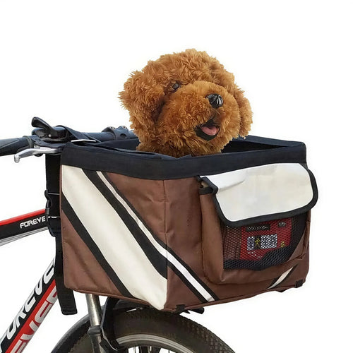 Brown and white fabric bicycle basket with a small brown dog inside, mounted to black handlebars.