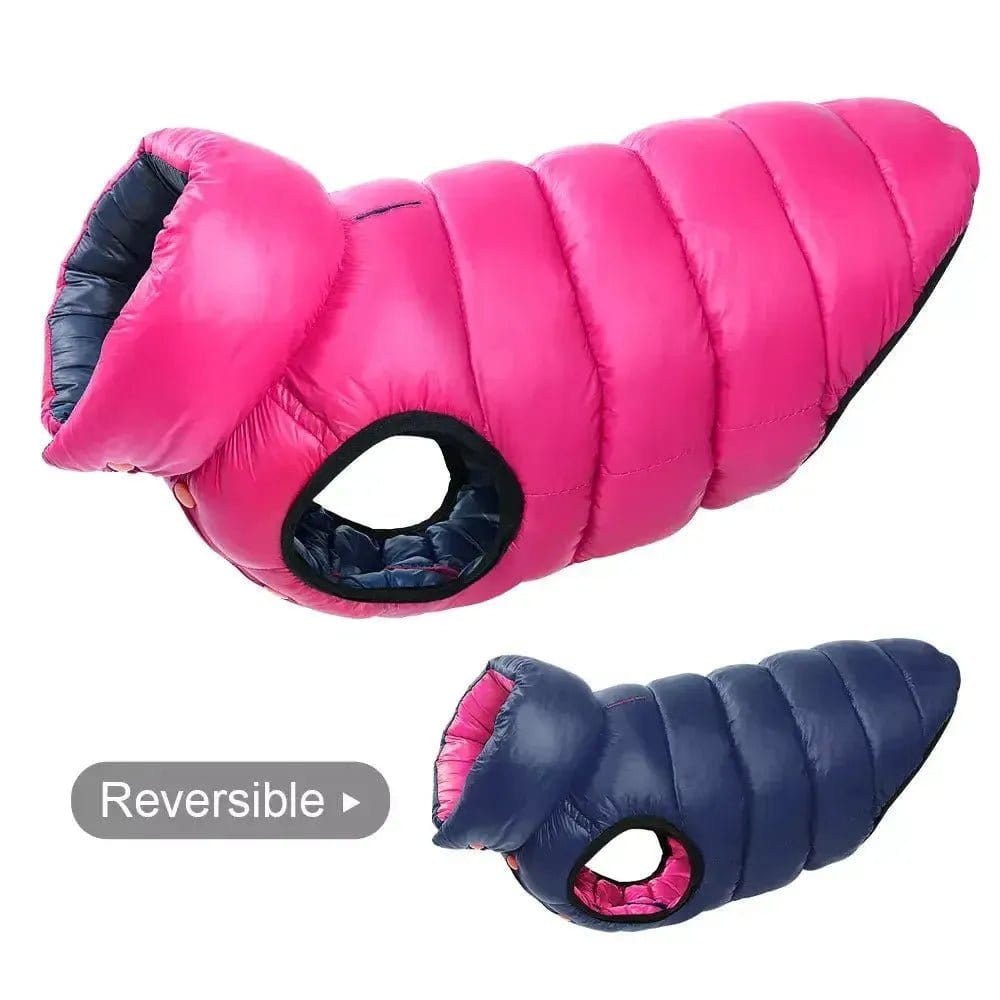 Two quilted reversible dog vests in pink and navy blue fabric, shown from a side profile on a white background.