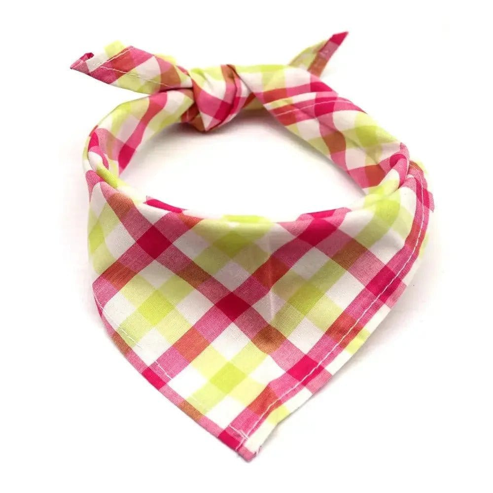 Pink and green plaid fabric dog bandana tied in a loop on a white background.