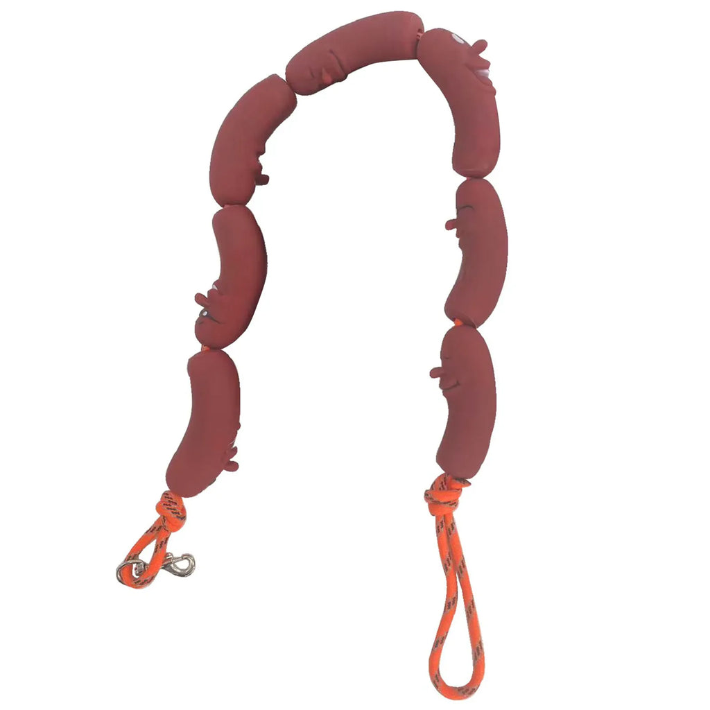 A dog training toy made of eight reddish-brown padded sausage-shaped links connected by an orange rope with metal clips, shown on a plain white background.