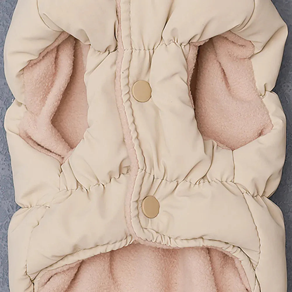 Cream padded fabric dog coat with two snap buttons and a pink fleece lining.