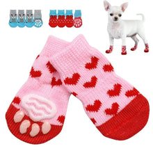 Pink and red knit dog socks with red heart patterns, featuring a raised paw print on the sole. A small white Chihuahua is shown wearing red socks in the top right corner, and three pairs of dog socks are displayed in the top left.